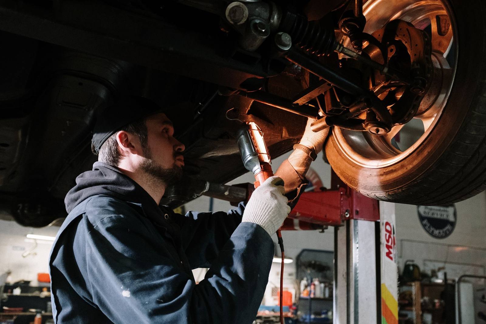 Mechanic inspecting a wheel on a lift at Tom Geraghty Tyres in Waterford